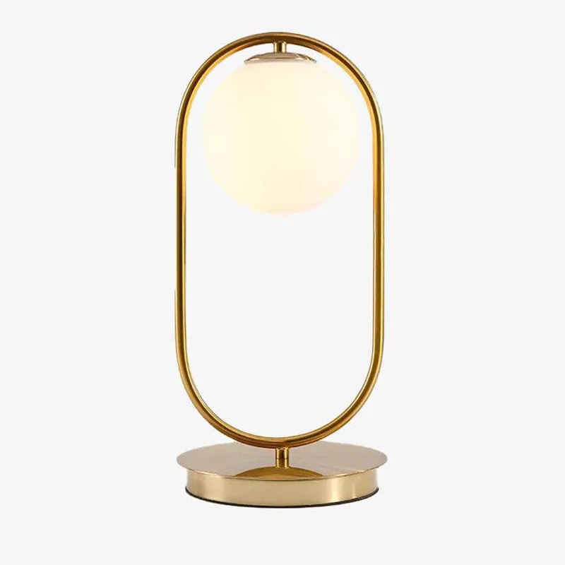 Lampe de chevet dorée avec boule en verre.